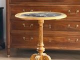 une petite table ronde avec un plateau en marbre posé sur un piètement en bois