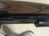 the gun is sitting on the floor next to a person ' s feet
