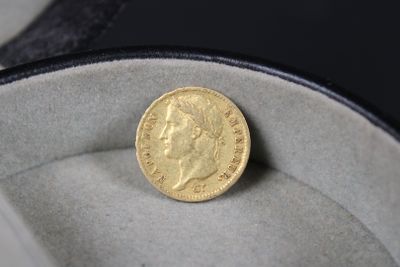 une pièce d'or posée dans une boîte sur une surface noire