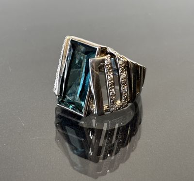 une image d'une bague avec une topaze bleue entourée de diamants