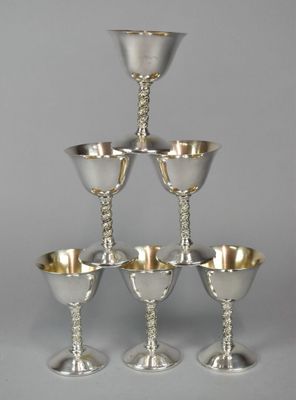 six silver goblets stacked on top of each other on a table