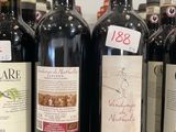 plusieurs bouteilles de vin sont alignées sur une étagère