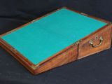 an old wooden box with a green felt inside on a black background