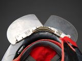 a close up of a helmet with a red ribbon on it
