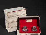 a pair of silver cuffers in a wooden box with red velvet lining
