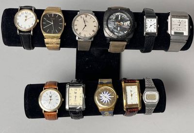 cinq montres différentes exposées sur un présentoir noir