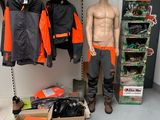 a mannequin of a man standing in front of a display of clothing