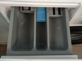 underside view of a white and blue dishwasher with a blue handle