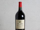 a bottle of red wine sitting on a wooden table