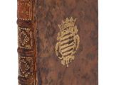un vieux livre avec un emblème en or sur la couverture