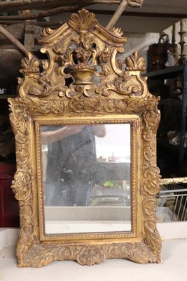 un cadre doré avec un miroir posé sur une table
