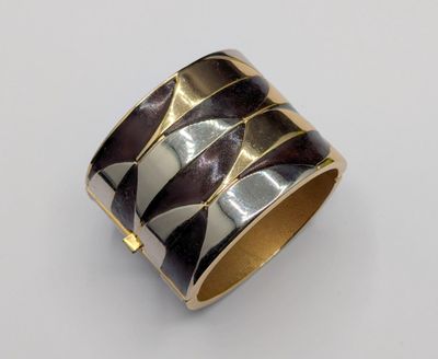 a close up of a silver and gold ring on a white surface