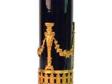 un vase noir et doré surmonté d'une statuette