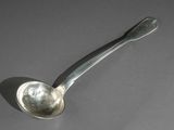 une cuillère en argent avec un manche de cuillère sur une table