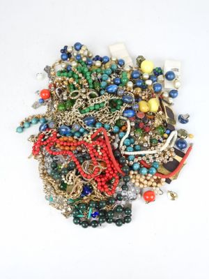 a pile of assorted beads and chains on a white surface