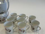 six cups and a teapot sitting on a table