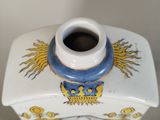 a white vase with a blue and yellow design on it