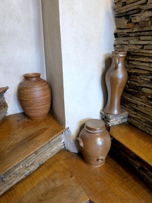 two vases sitting on the steps of a stone wall
