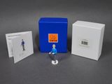 the figurine is sitting next to a box of cards and a card