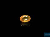a yellow sapphire stone on a black surface
