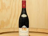 une bouteille de vin posée sur un tonneau en bois