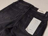 the back of a pair of black jeans with a white tag on it