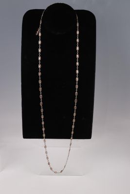 un ensemble composé d'un collier et de boucles d'oreilles, présenté sur un présentoir