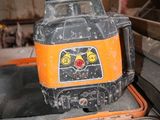 an orange and black machine sitting on top of a piece of metal