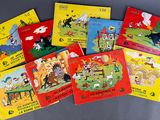 several children ' s books are lined up on a gray surface