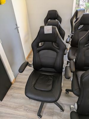 de nombreuses chaises de bureau en cuir noir alignées en rang