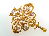 an image of a gold brooch with pearls and diamonds on a white background