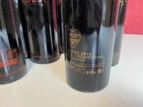 three bottles of red wine are lined up on a table
