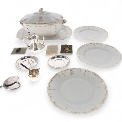 une table dressée en blanc, avec des assiettes et des couverts blancs et argentés