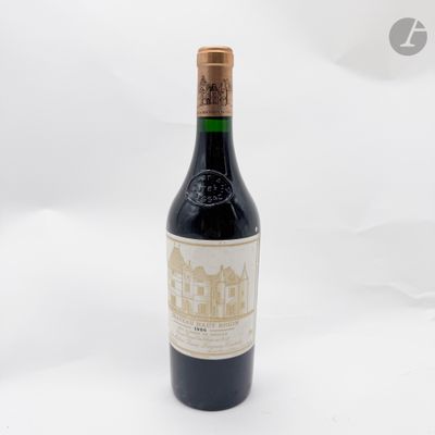 une vieille bouteille de vin posée sur une surface blanche