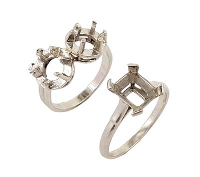 two silver rings with diamonds on them on a white background