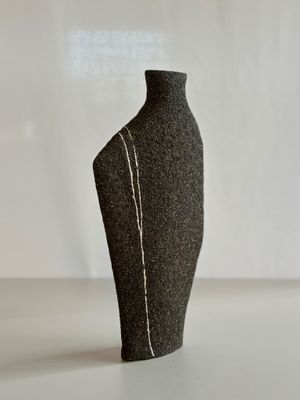 un mannequin noir posé sur une table blanche, avec un fond blanc