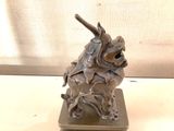 a statue of a dragon with a sword on top of a table
