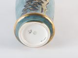 a blue vase with a bird on it on a white surface