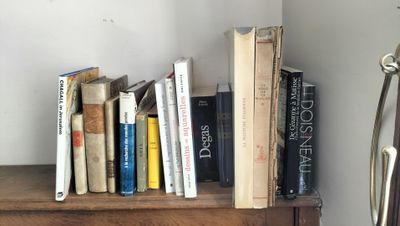 une étagère sur laquelle se trouvent des livres et une horloge