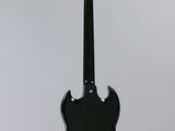 a black electric guitar hanging from a white wall