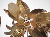 a gold flower with a white cord attached to it