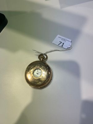 une montre de poche en or posée sur une table blanche