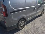 une camionnette argentée garée sur un parking, équipée d'une galerie de toit
