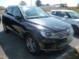 Le SUV Volkswagen noir est garé sur un parking, à côté d'autres voitures.