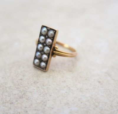 a close up of a gold ring with pearls on it