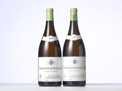 two bottles of wine sitting on top of a table next to each other