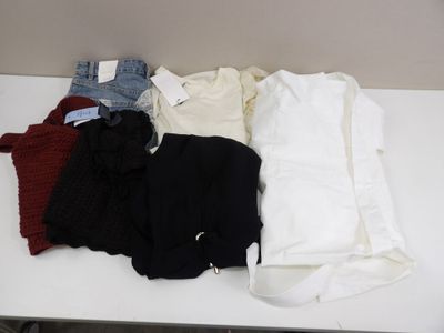 a white table with a bunch of clothes on top of it