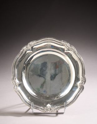 a silver plate on a stand on a white surface