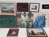 une table sur laquelle sont posées plusieurs œuvres d'art encadrées