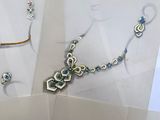 three pieces of jewelry on display in a glass case